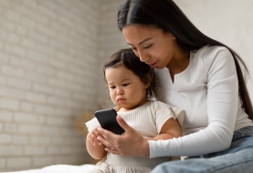 Peuter speelt samen met moeder op smartphone
